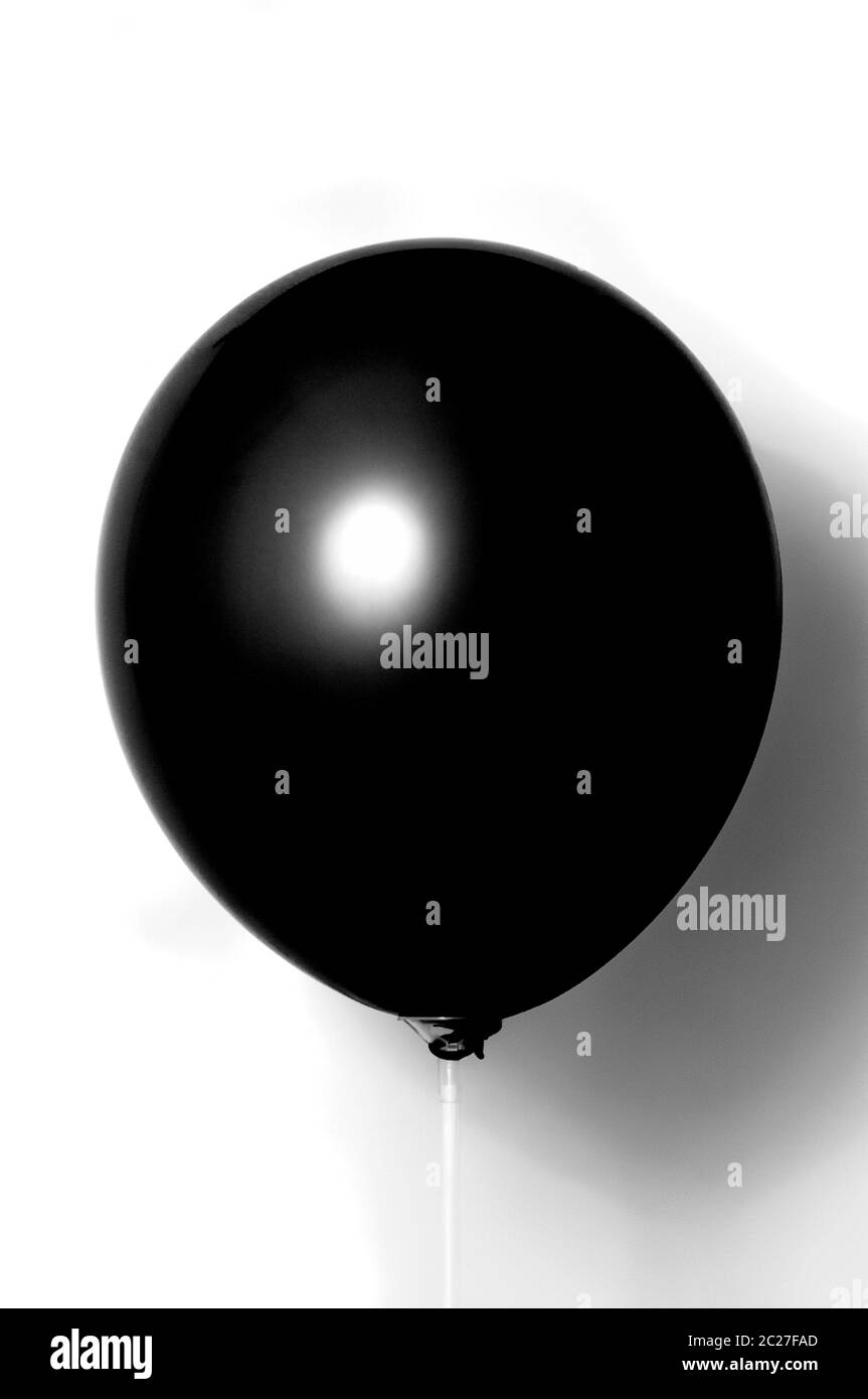 Palloncino nero su sfondo bianco con ombra. Abbagliamento laterale Foto Stock