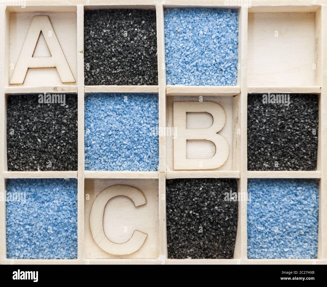 Scatola di legno con sabbia e lettere a B C. Foto Stock