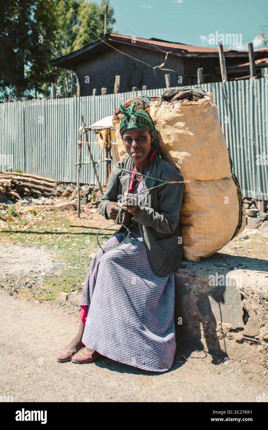 Donna etiope riposante con sacco di carbone, Etiopia Foto Stock