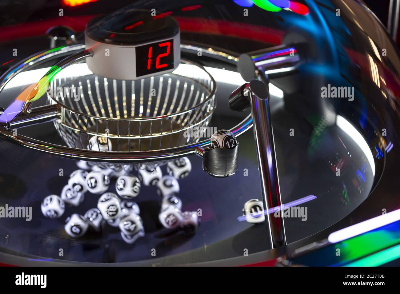Palline di lotteria bianche e nere in una macchina di bingo rotante. Numero 12 Foto Stock