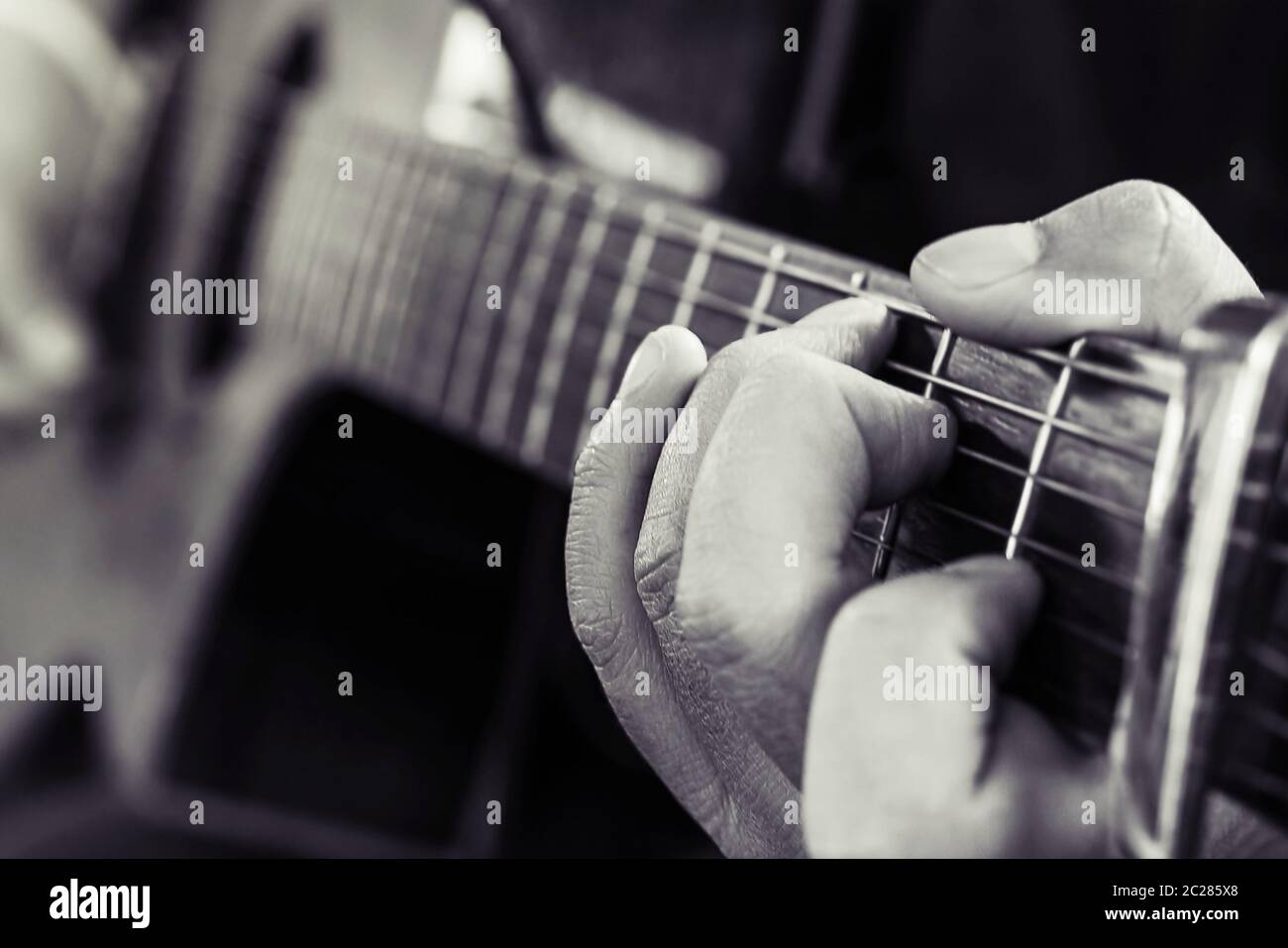 La pratica di suonare la chitarra, mano di giovani uomini a suonare la  chitarra la corda C, il fuoco selettivo sul dito Foto stock - Alamy