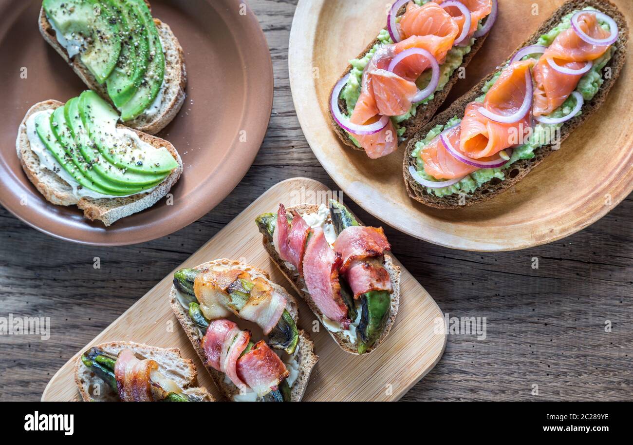 Toast con avocado e diversi condimenti Foto Stock