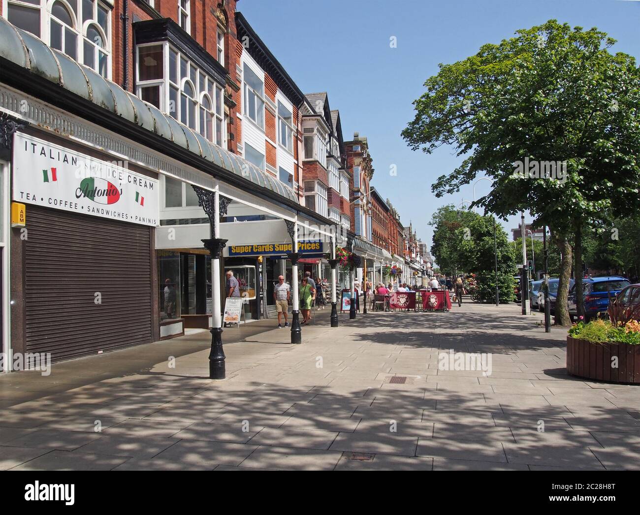 persone sedute in caffè all'aperto e camminate davanti ai negozi nella storica area dello shopping di lord street a southport merseyside Foto Stock