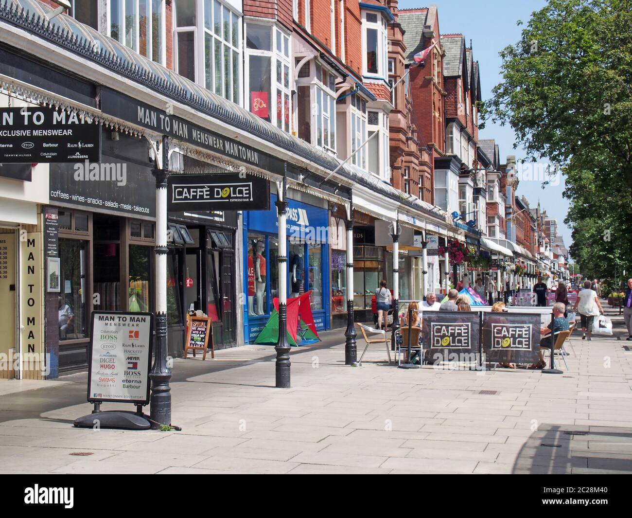 persone sedute in caffè all'aperto e camminate davanti ai negozi nella storica area dello shopping di lord street a southport merseyside Foto Stock