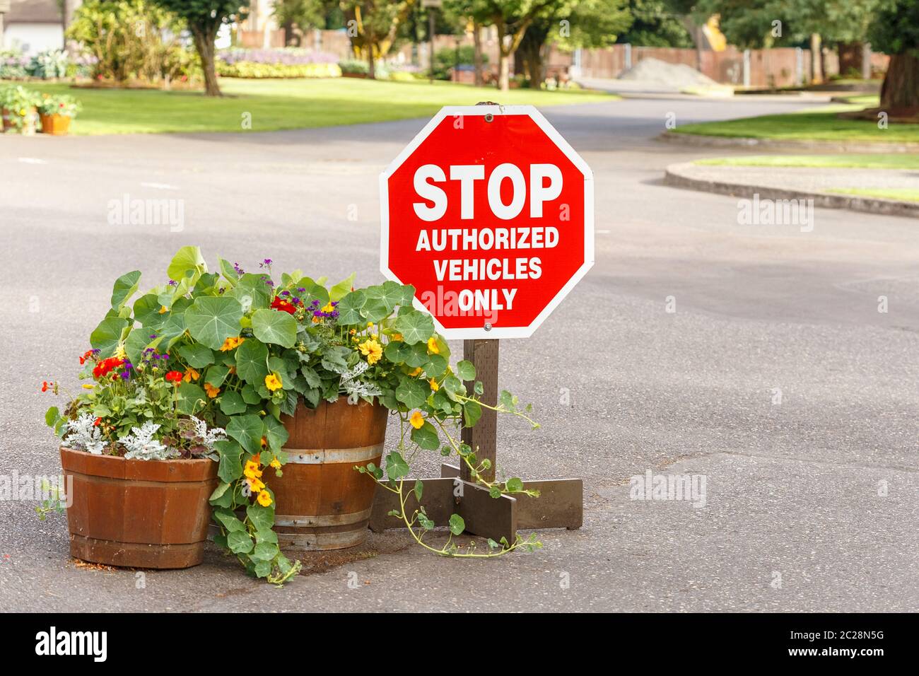 Sosta solo per i veicoli autorizzati, cartello con i bellissimi fiori in vaso all'ingresso della proprietà privata Foto Stock