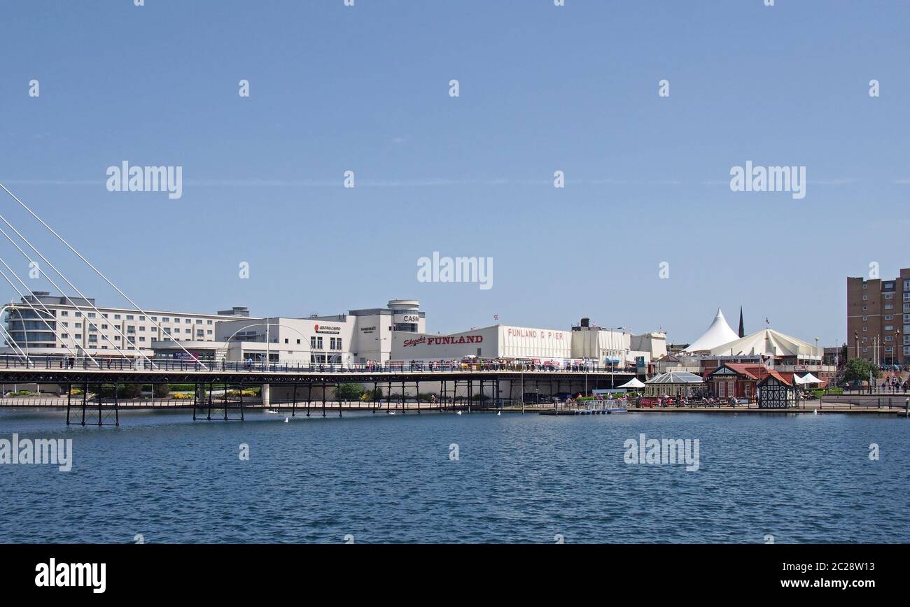 il ponte sospeso e il molo che attraversa il lago a southport merseyside con una vista sugli alberghi e gli edifici della città Foto Stock