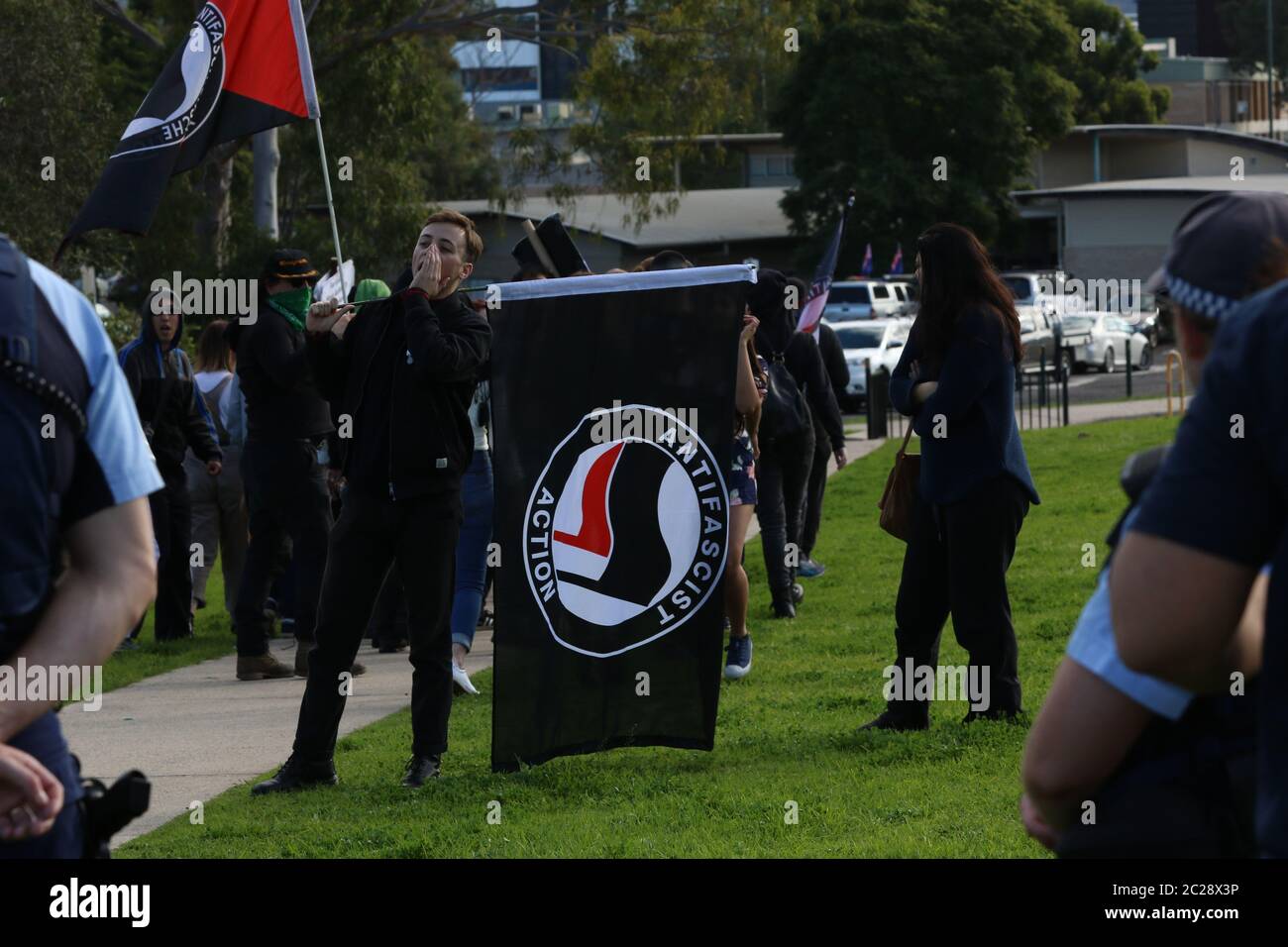 Nella foto: I contronotori di ‘Antifa’ partono presto perseguiti da due giornalisti radiofonici della comunità femminile che cercano di intervistarli senza successo. Festa per Foto Stock