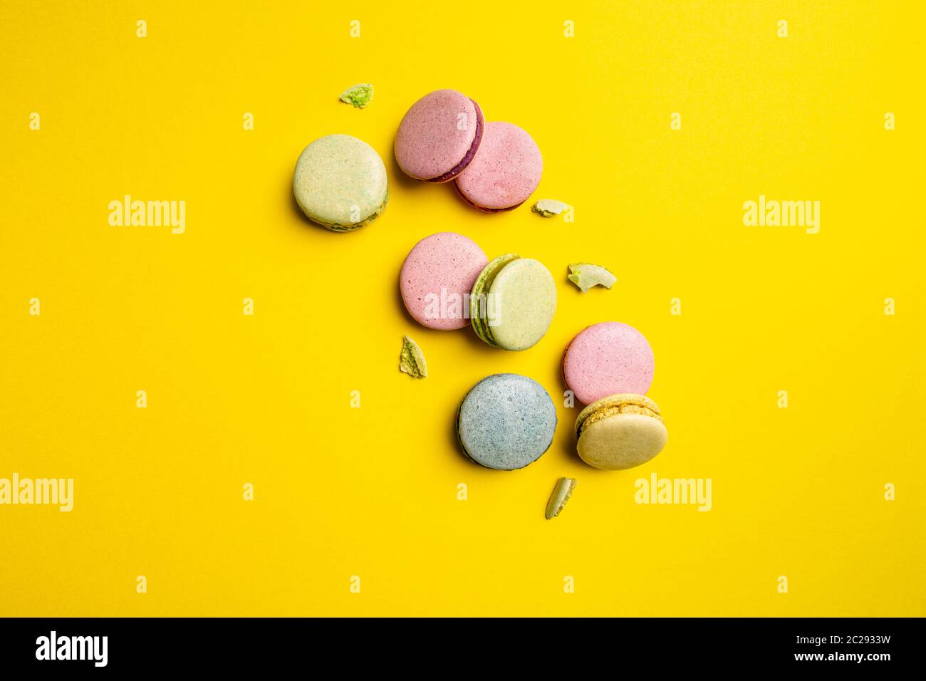 Torte colorate di macaron su sfondo giallo, spazio per il tuo testo Foto Stock