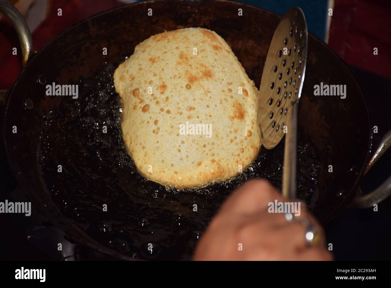 Preparazione deliziosa di bhatoora o bhature (pane fritto) in corso. Bhatoora è un soffuso pane lievitato fritto e fritto proveniente dal subcon indiano Foto Stock