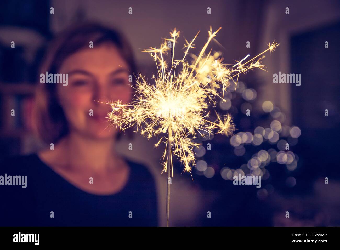 La ragazza felice sta tenendo uno scintilla al tempo di Natale Foto Stock