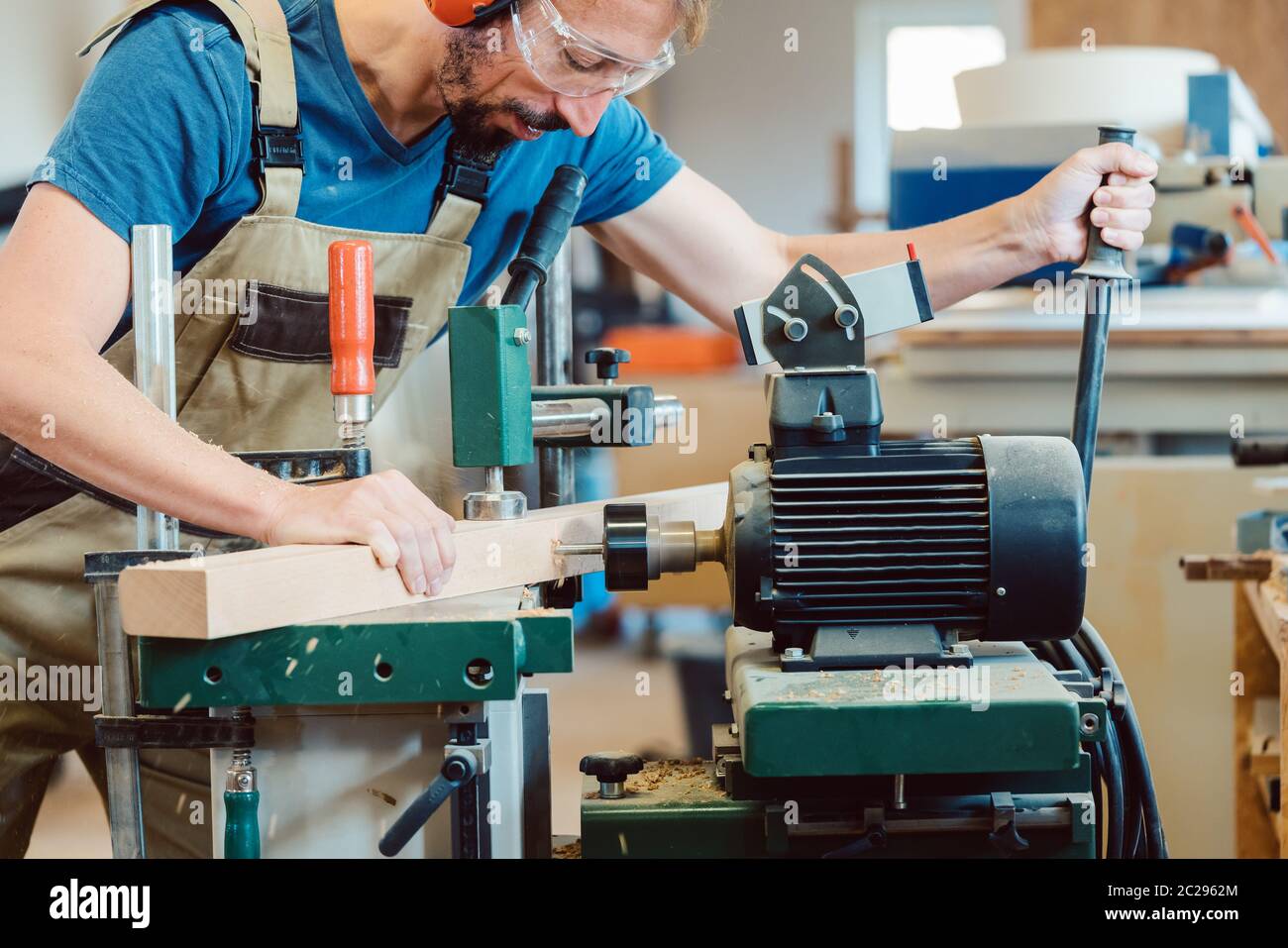 Falegname che fa scalinata che fora i fori nella scala con una macchina Foto Stock