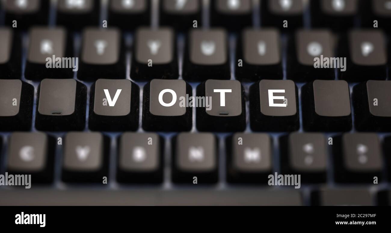 Concetto di voto online. Parola di voto scritta sulla tastiera. Tasti neri con lettere bianche per la selezione sulla tastiera del pc. Sfondo pulsanti sfocati. Foto Stock