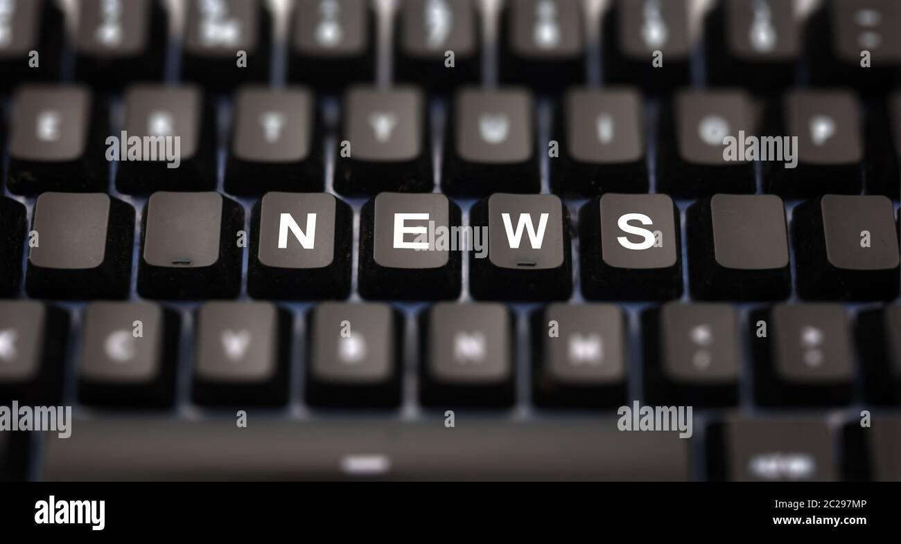 Notizie online, giornalismo concetto. Parola di notizie scritta sulla tastiera. Tasti neri con lettere bianche messaggio per articoli di stampa sulla tastiera del pc. Pulsanti di sfocatura ba Foto Stock