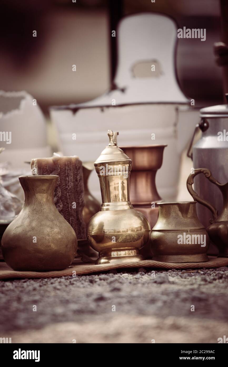 Teiera antica, crema e altri utensili in un mercato delle pulci. Vecchio metallo stoviglie a una vendita garage. Foto Stock