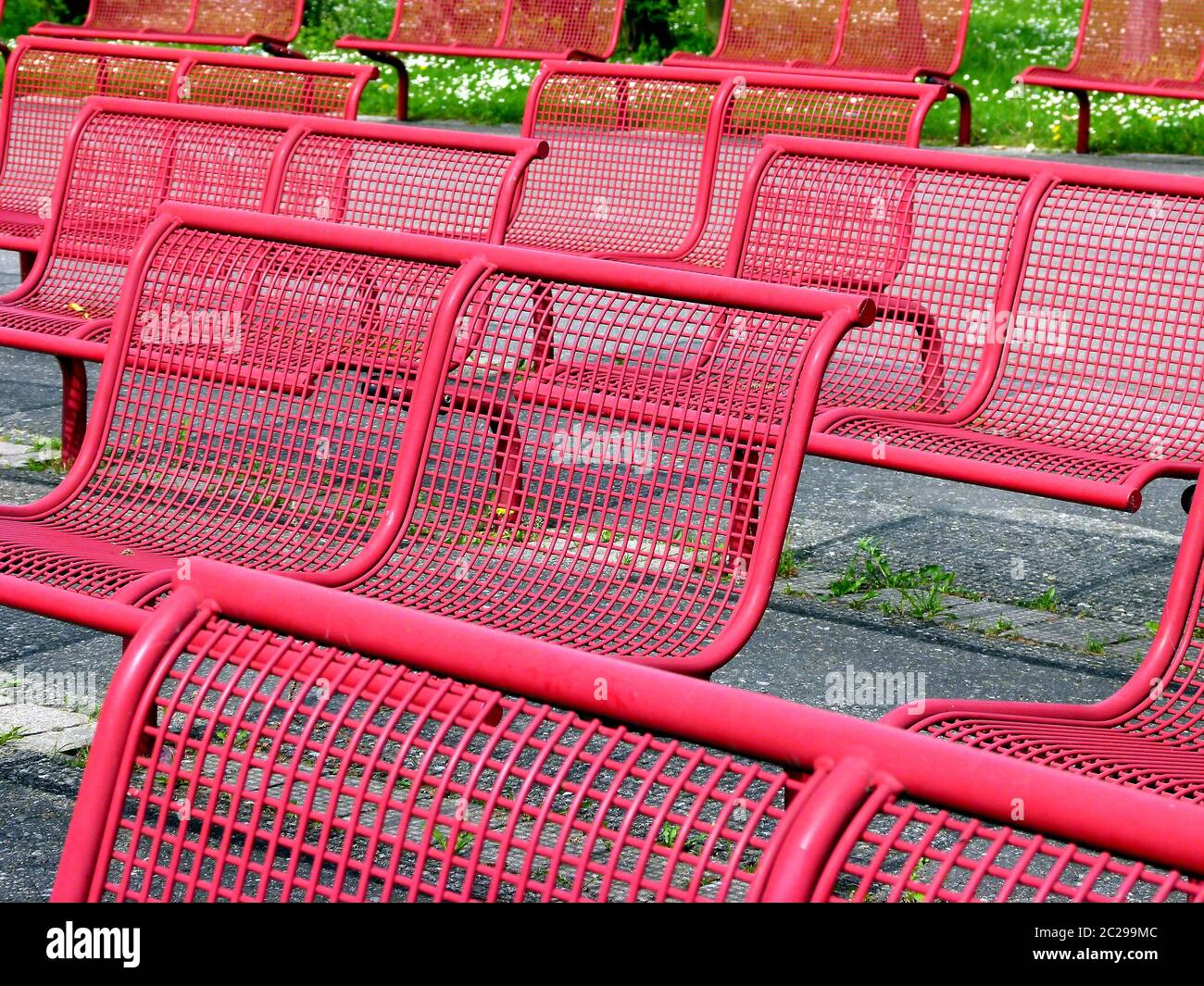 File con sedie in metallo rosso e sfondo verde Foto Stock