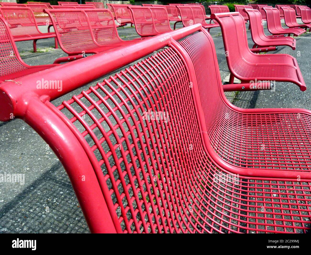 File con sedie in metallo rosso e sfondo verde Foto Stock