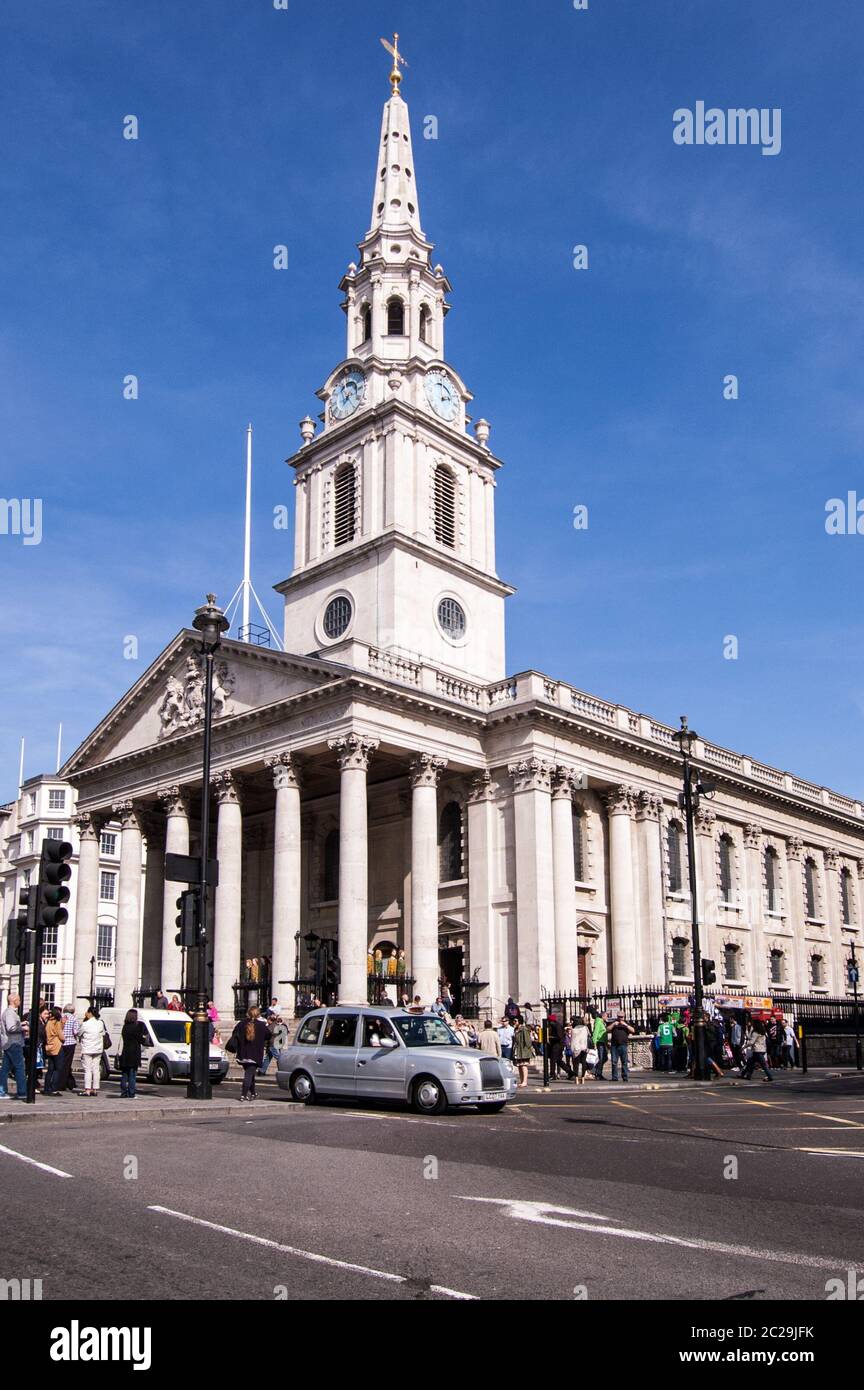 Londra, UK - 25 marzo 2012: Traffico e pedoni fuori dalla chiesa simbolo di St Martin nei campi in Trafalgar Square, Londra su una spoletta soleggiata Foto Stock