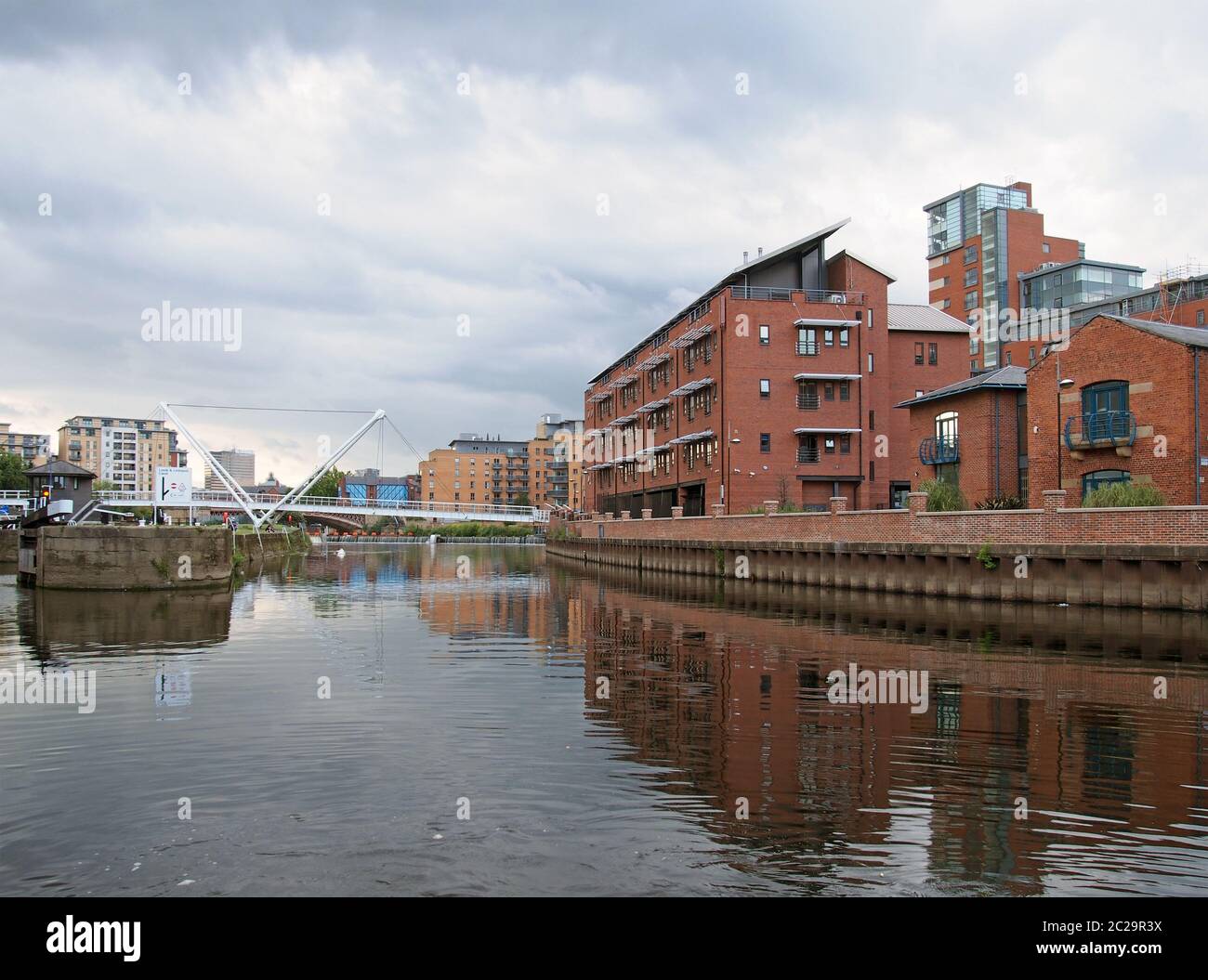 il fiume aire si unì al canale leeds liverpool nell'area portuale di clarence con edifici che si riflettono nelle chiuse d'acqua e nei bri Foto Stock