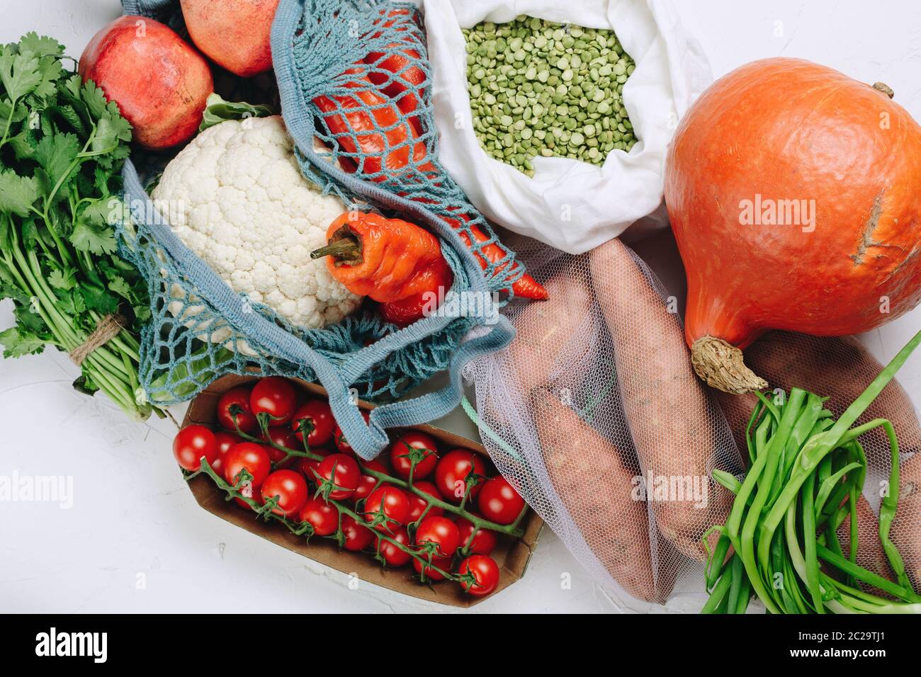 Flatlay di zero rifiuti acquisti alimentari sostenibili: Uva, pomodori, piselli, verdi, nocciole ecc in sacchetti di produzione Foto Stock