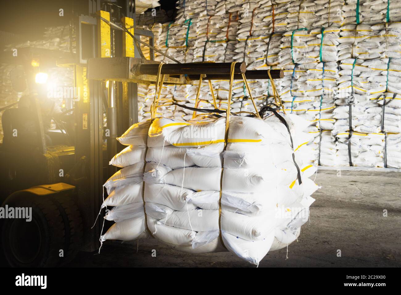 Attività di deposito di zucchero, carrello porta sacchi di zucchero all'area di riempimento del contenitore per l'esportazione. Concetto di logistica industriale. Foto Stock