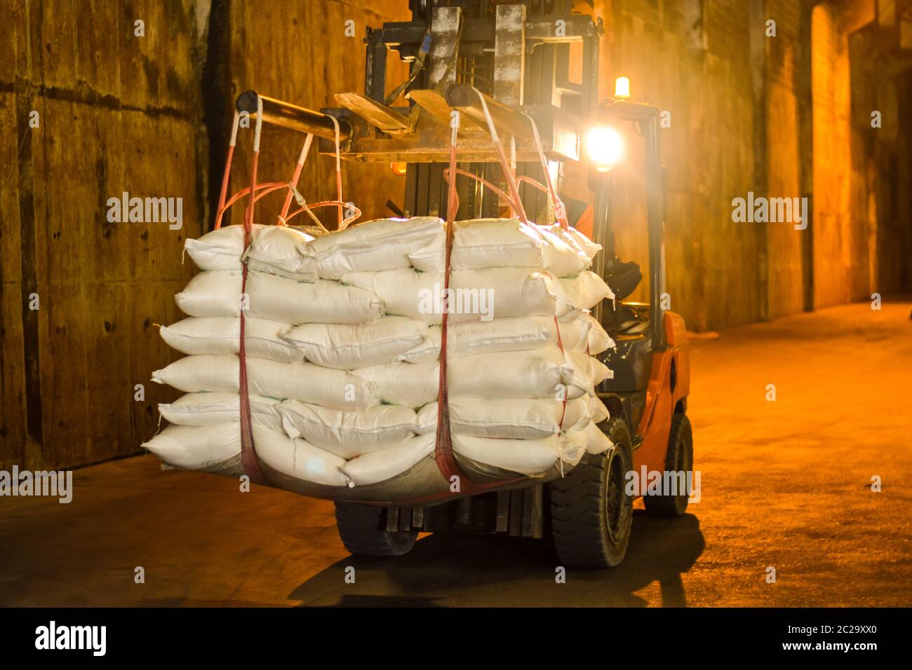 Attività di deposito di zucchero, carrello porta sacchi di zucchero all'area di riempimento del contenitore per l'esportazione. Concetto di logistica industriale. Foto Stock