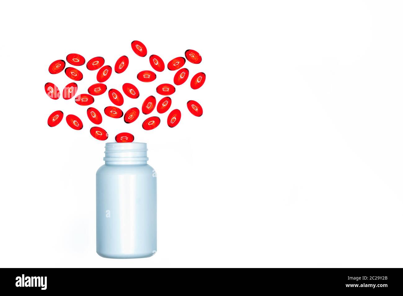 Versare morbido rosso capsula di gel pillole fuori del flacone di farmaco isolati su sfondo bianco. Red capsula di gelatina soffice vitamine e integratori alimentari. Pharmaceut Foto Stock