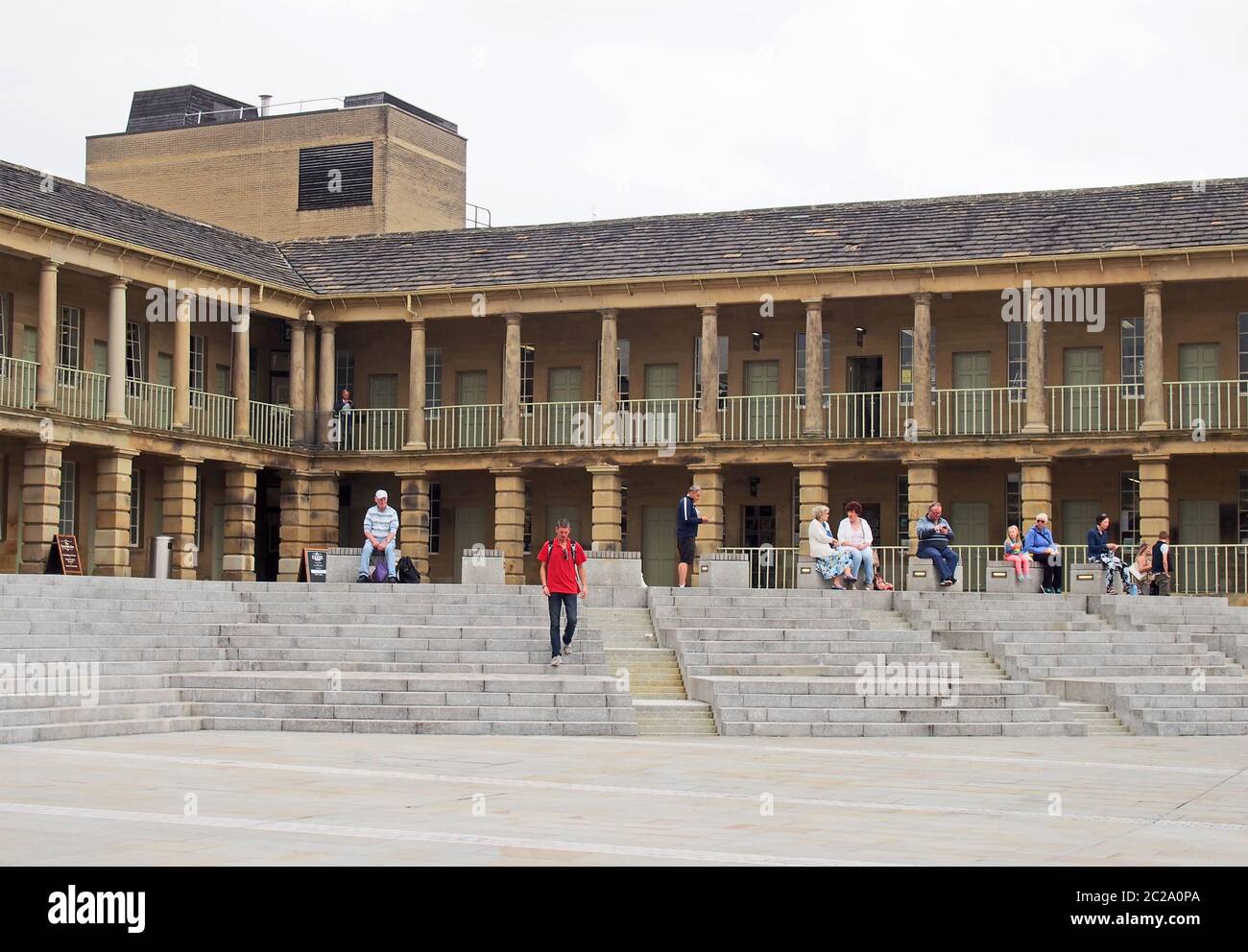 la gente camminava e sedeva sui gradini della sala del pezzo in halifax west yorkshire Foto Stock