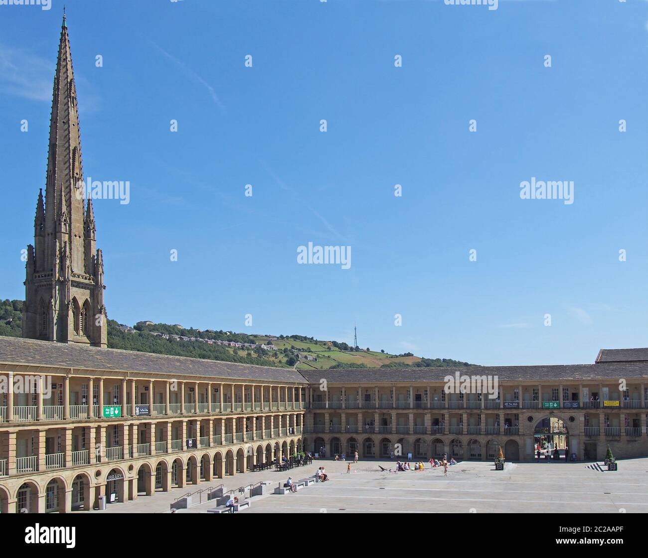la gente si rilassa e gode il sole estivo nella piazza della sala del pezzo halifax nella parte occidentale dello yorkshire Foto Stock