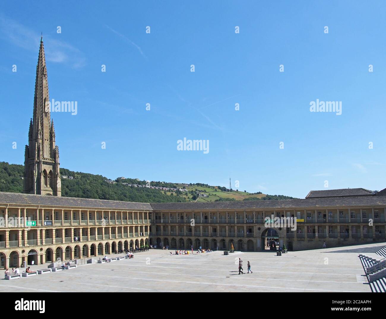 la gente si rilassa e gode il sole estivo nella piazza della sala del pezzo halifax nella parte occidentale dello yorkshire Foto Stock
