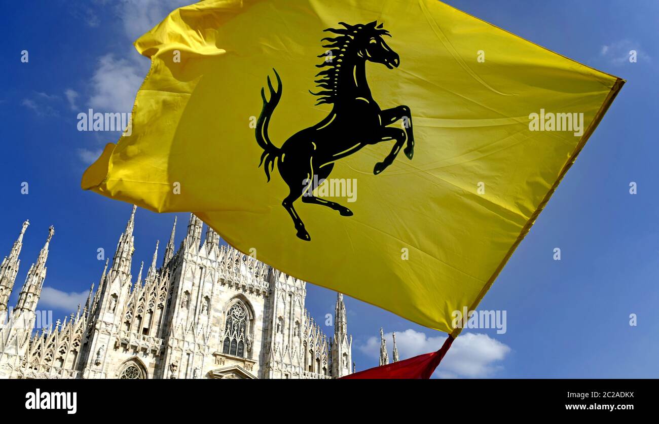 I tifosi Ferrari hanno fatto sventolare una bandiera Ferrari in piazza Duomo per celebrare il 90° anniversario della Ferrari , a Milano. Foto Stock
