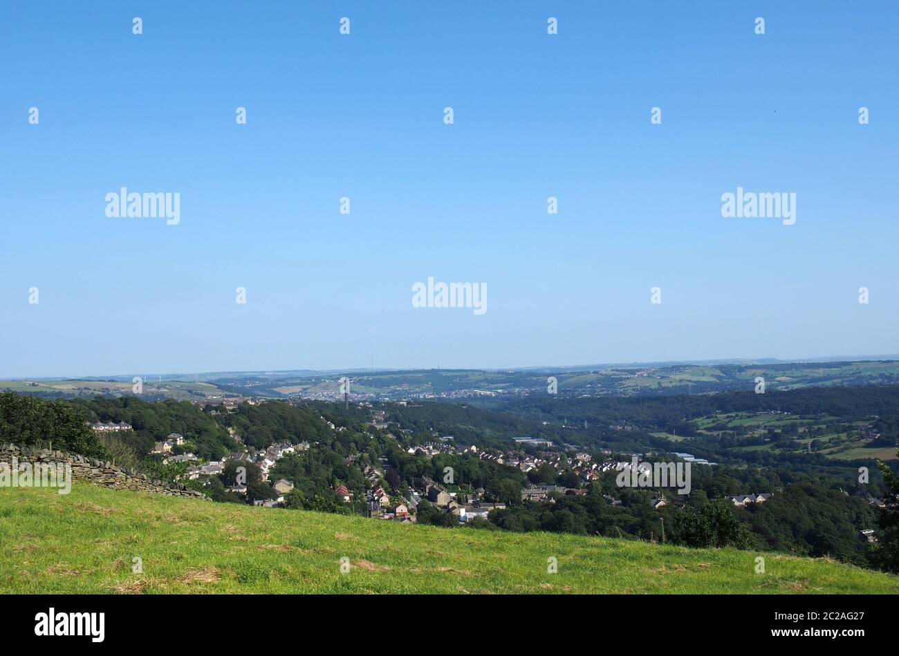 Una vista panoramica di halifax dall'alto circondata da colline di Fields e pennine e un cielo estivo blu Foto Stock