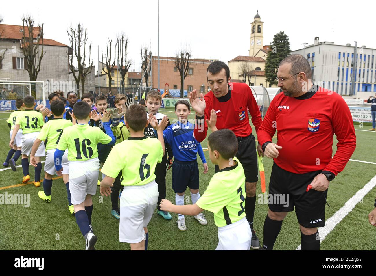 I giocatori di calcio dei bambini si salutano battendo i cinque con l'arbitro. Foto Stock