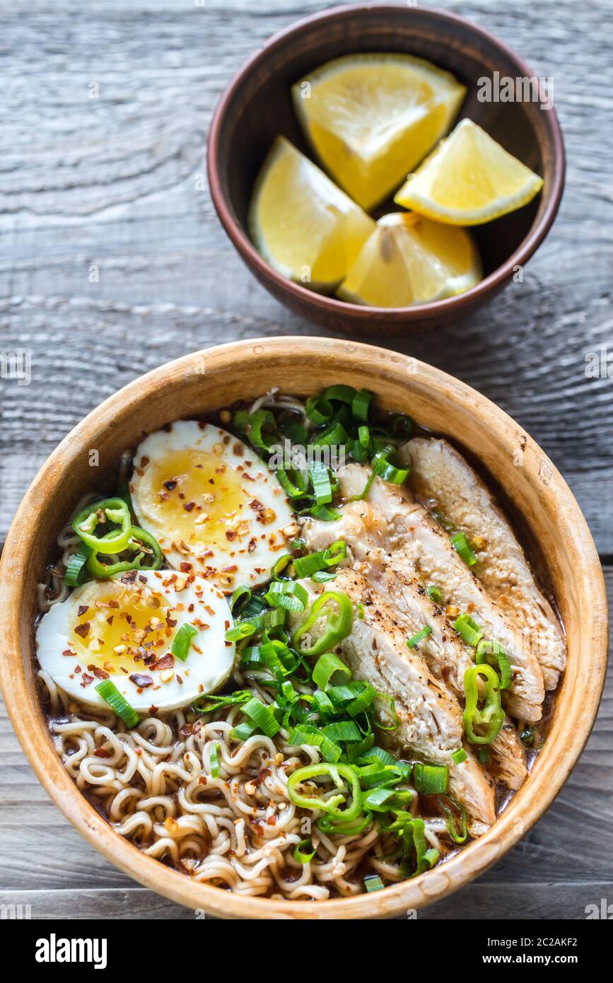 Ciotola di zuppa di ramen di pollo sul tavolo di legno Foto Stock