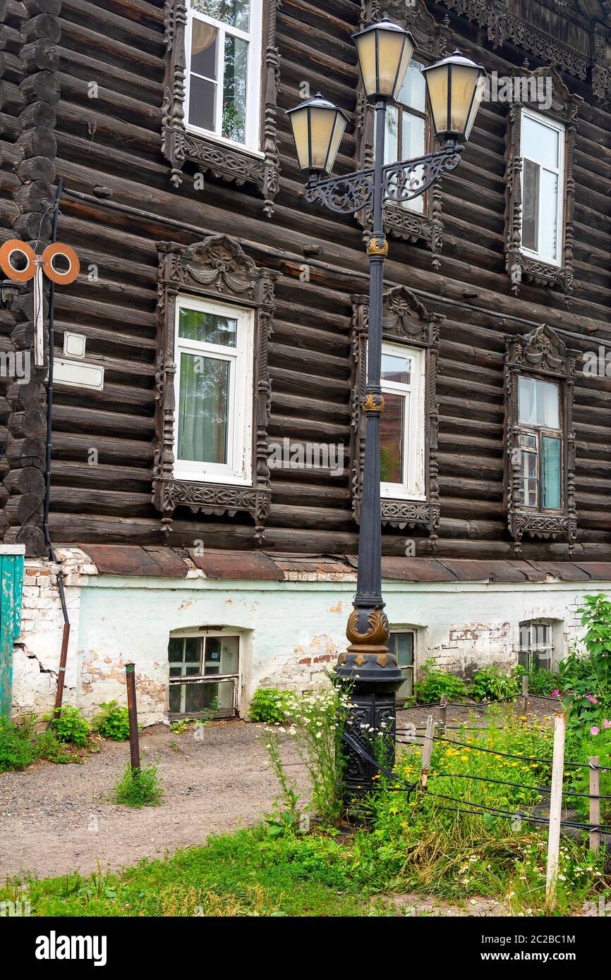 Tomsk, lampada da strada vicino a una vecchia casa di legno multiappartamento Foto Stock