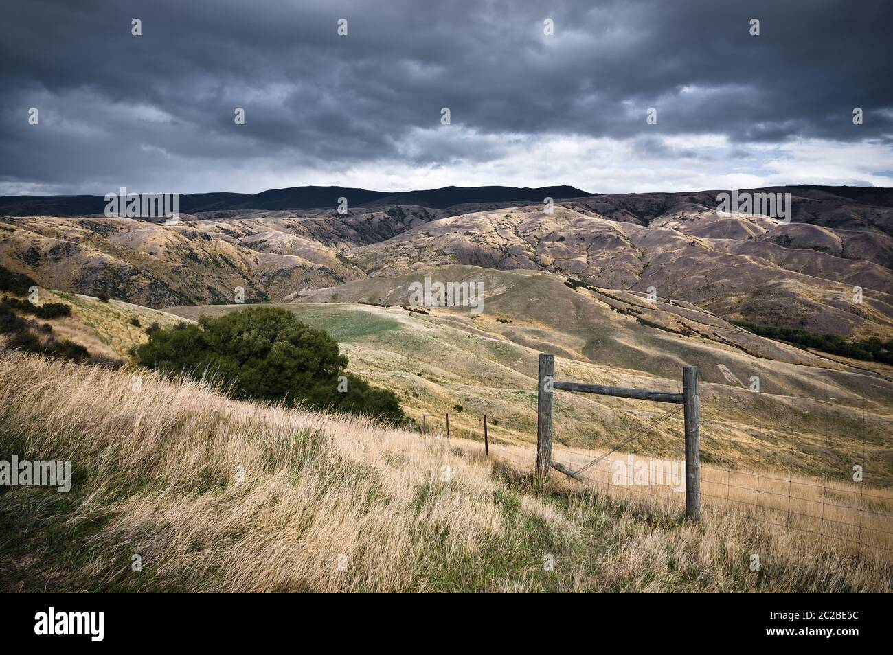 Le colline texturali all'estremità meridionale della Lindis Valley a Otago, Nuova Zelanda, in una giornata di lavoro. Foto Stock