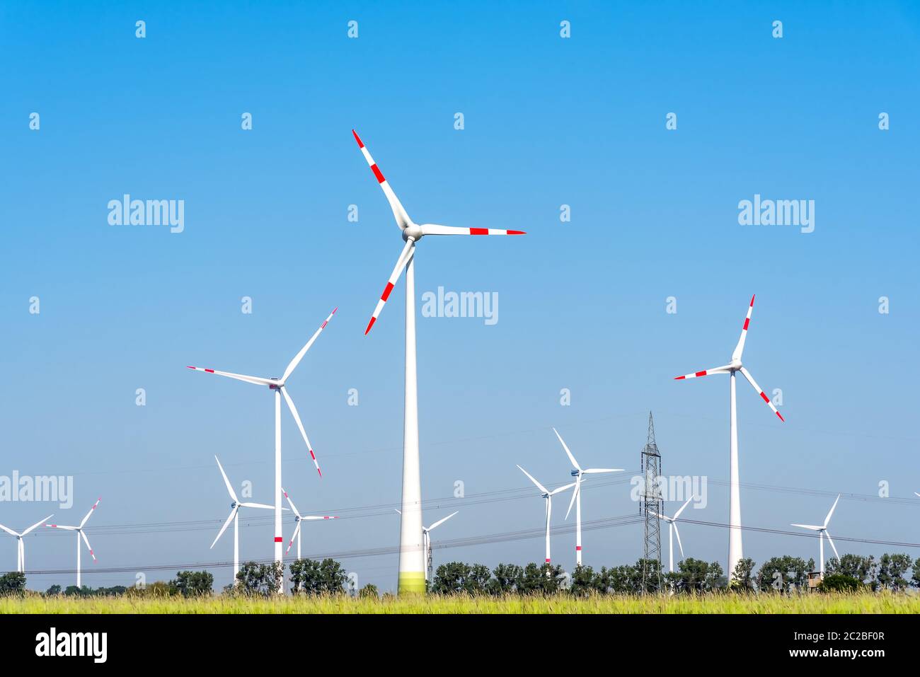 Le turbine eoliche e alcune linee di alimentazione aeree visto in Germania Foto Stock