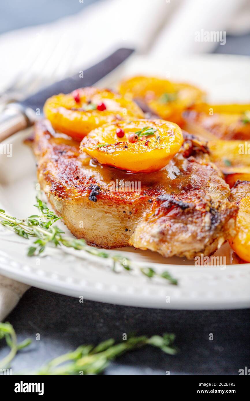 Succosa bistecca di carne di maiale con albicocche,timo e patate. Foto Stock