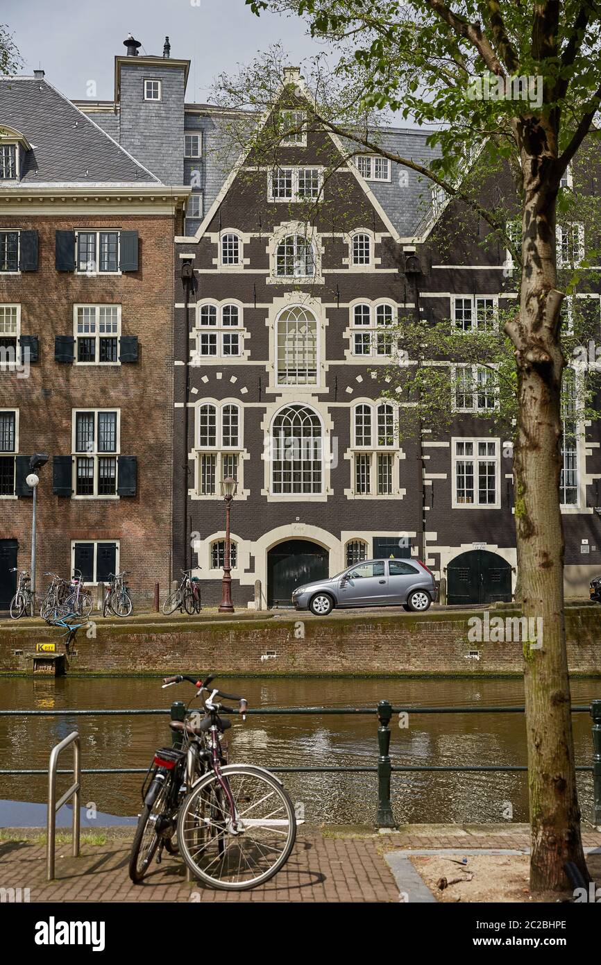 Canale di Amsterdam con case tipiche olandesi e case galleggianti durante la mattina in Olanda, Paesi Bassi Foto Stock