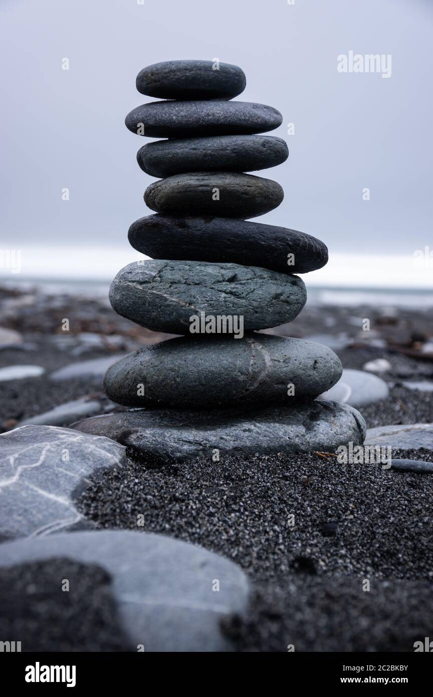 Un mucchio di pietre sulla spiaggia di Okarito sulla costa occidentale dell'isola meridionale della Nuova Zelanda. Foto Stock