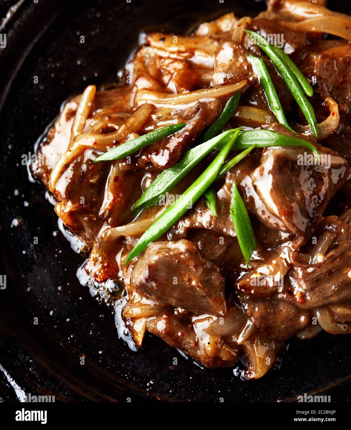 Carne arrosto con cipolla verde su fondo scuro primo piano. Dieta del keto o del Paleo Foto Stock