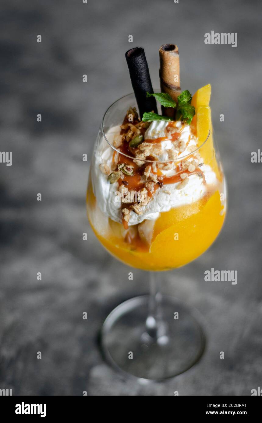 Organici di mango e frutto della passione tropical gelato Gelato in vetro del vino Foto Stock