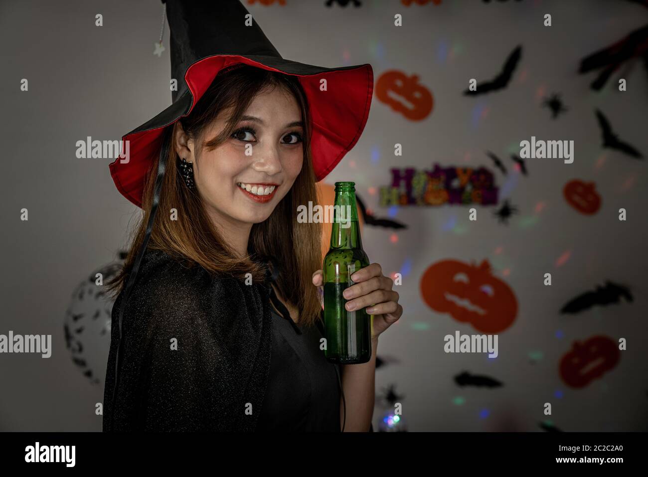 I giovani adulti e ragazza adolescente per celebrare una festa di Halloween festa di carnevale in costume di Halloween di bere alcolici birra Foto Stock