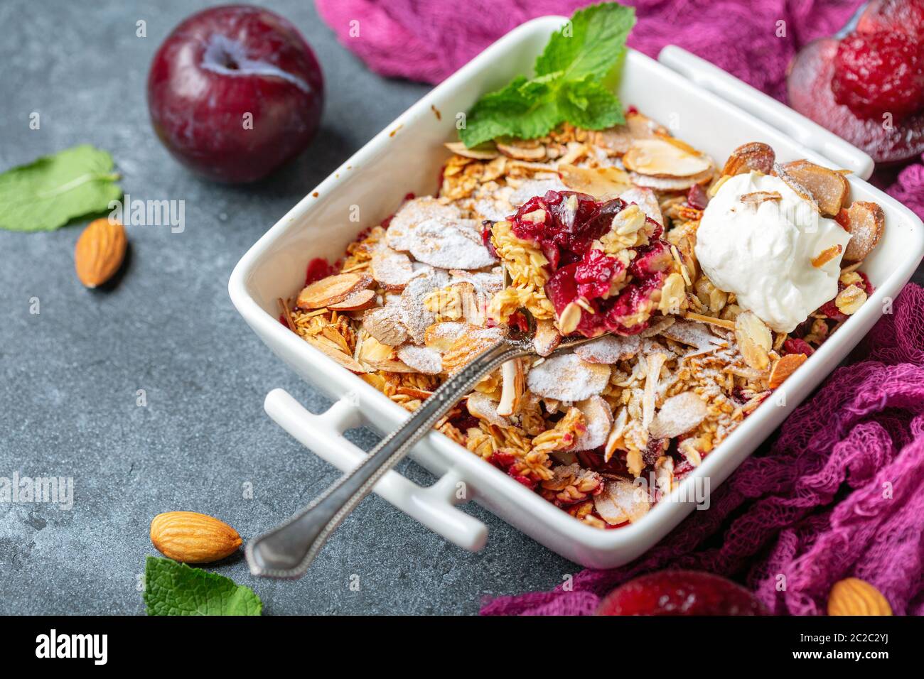 Crumble di prugna rossa con fiocchi d'avena croccanti e mandorla. Foto Stock
