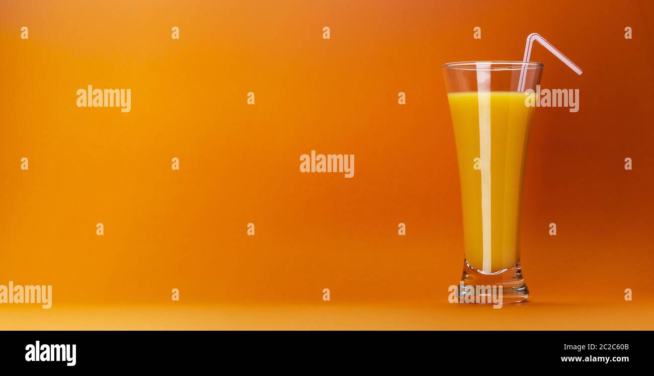 Bicchiere di succo d'arancia isolato su sfondo arancione colorato con spazio per il testo, fresco cocktail di agrumi Foto Stock
