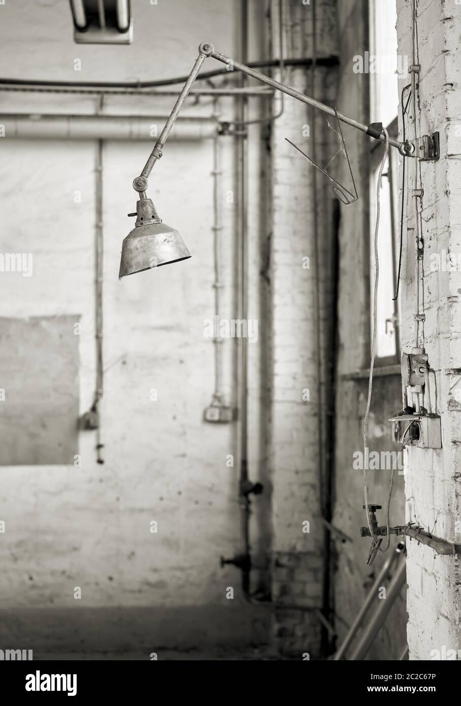 Lampada a un posto di lavoro in un laboratorio abbandonato Foto Stock