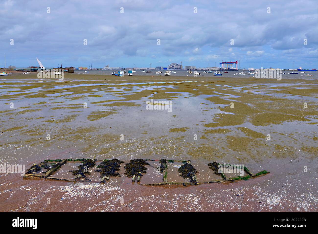 Spiaggia a bassa marea di Saint Brevin les Pins, con la piccola barca completamente insabbiata, nella regione della Loira nella Francia occidentale Foto Stock