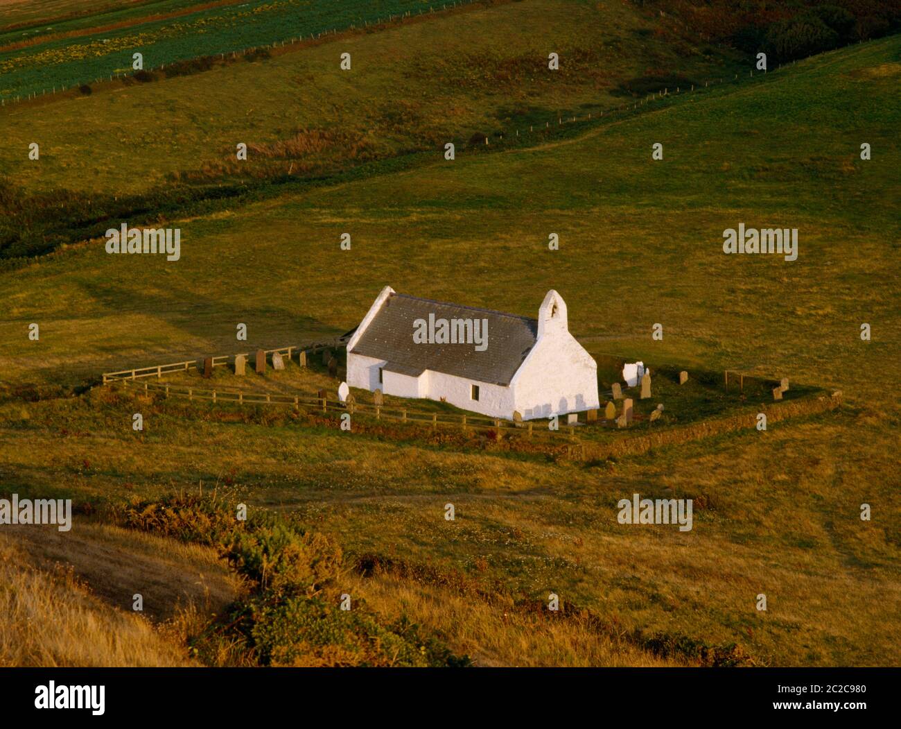 Vista e della chiesa di Santa Croce guardando giù dal promontorio di Foel y Mwnt, Cardigan; Galles; Regno Unito. Costruito 13 °-C14 sul sito della cella di un santo celtico. Foto Stock