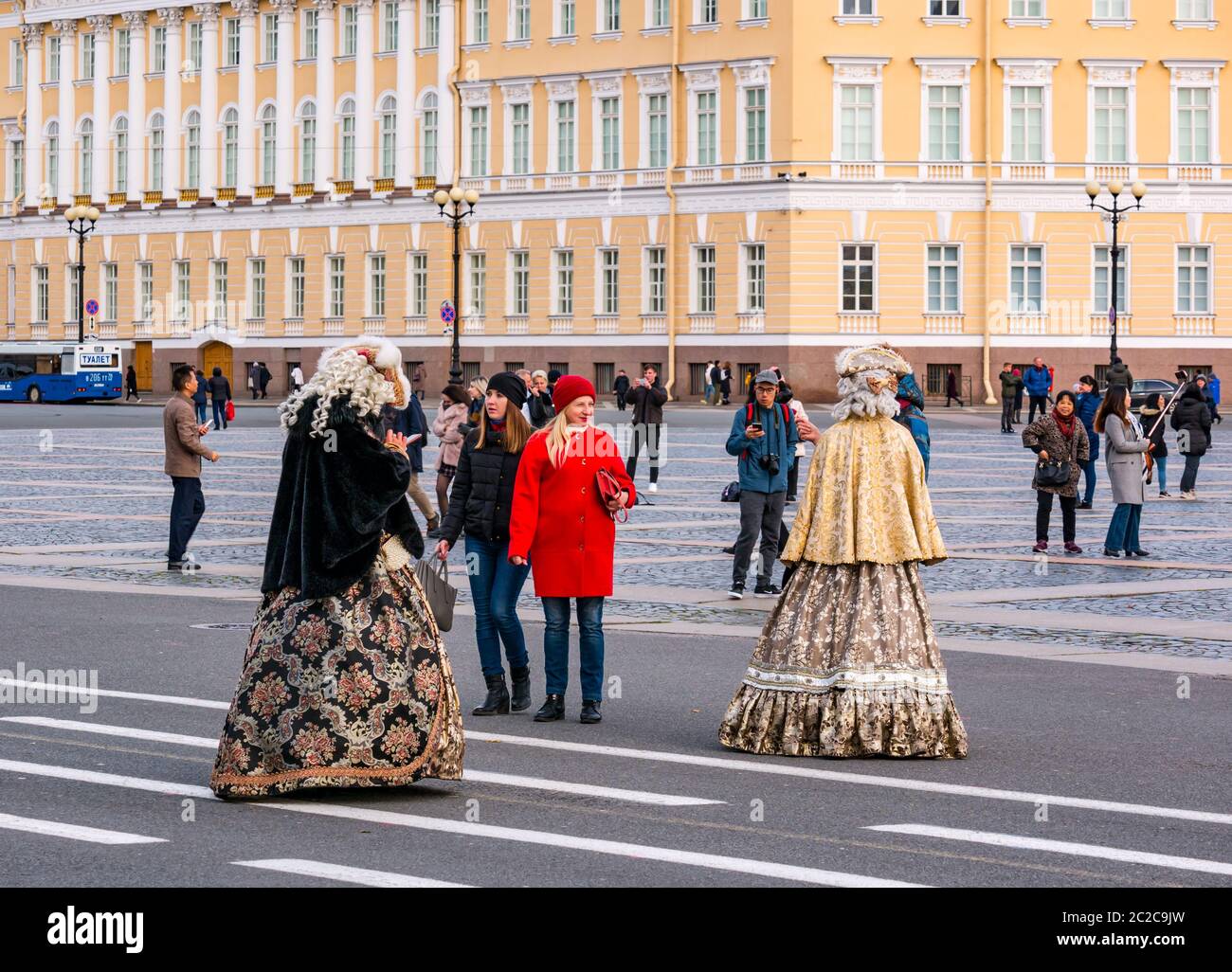 Turisti e donne in costume d'epoca in Place Square con il personale generale edificio, San Pietroburgo, Russia Foto Stock