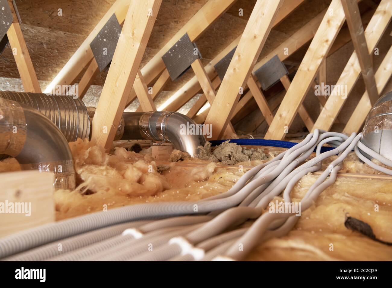 Tema industriale. Attico residenziale con alberi ad aria e impianti elettrici. Impianto di riscaldamento e raffreddamento. Foto Stock