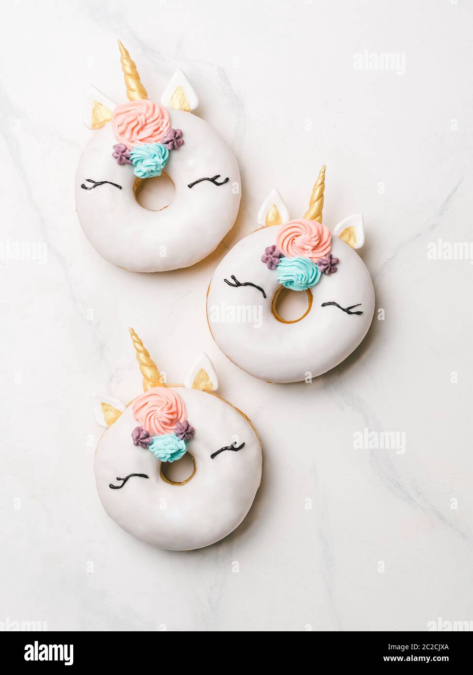 Ciambelle Unicorn su sfondo bianco in marmo Foto Stock
